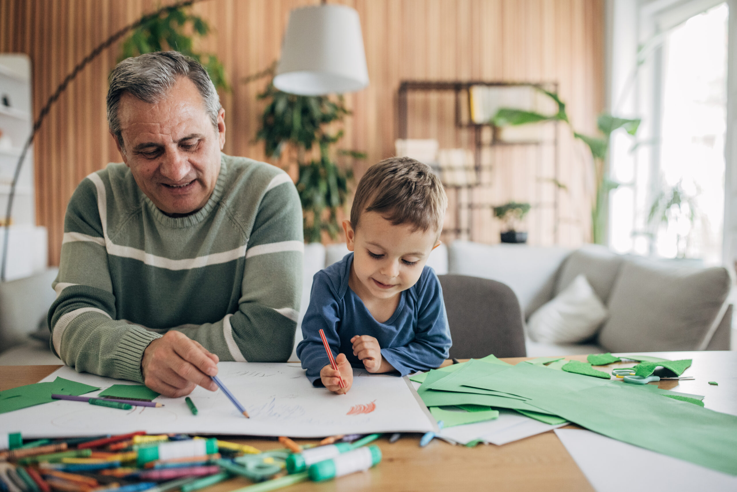 At home, a cheerful grandfather and grandson are playing